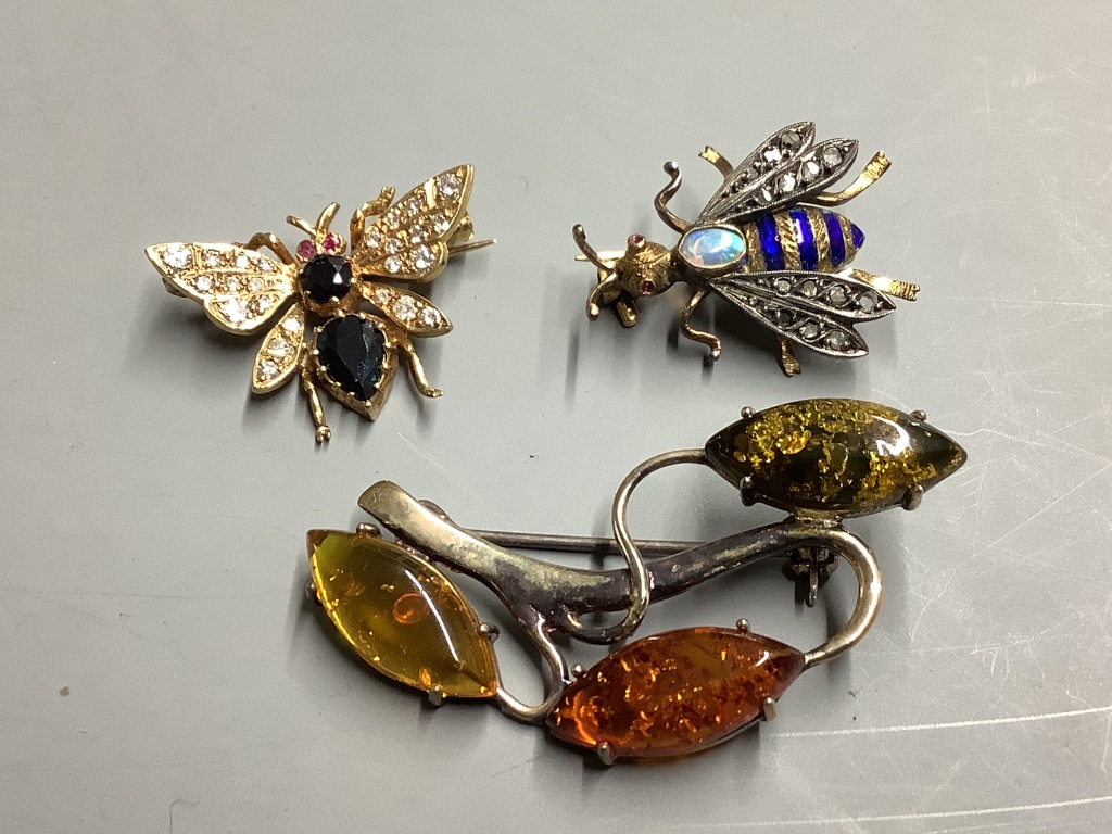 Two diamond and gemstone-set yellow metal insect brooches, largest 25mm, gross 7.8 grams and a silver and amber foliate openwork brooch